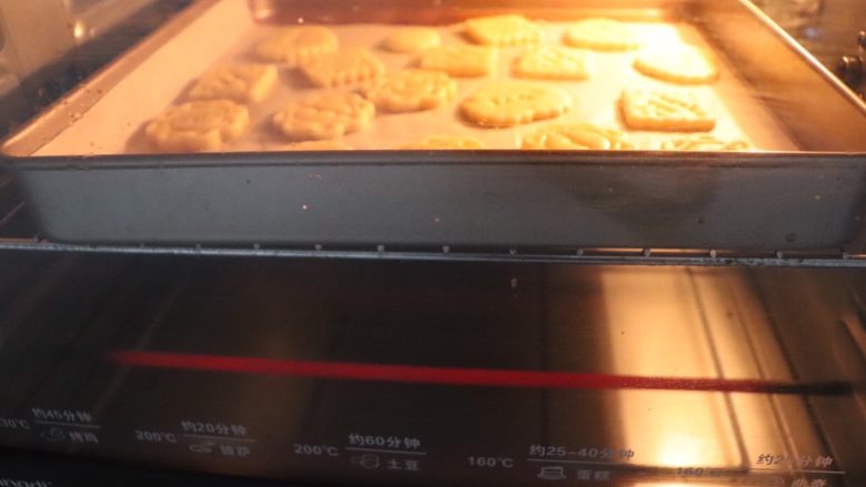 卡通曲奇饼干,烤箱预热170度。把饼干移到铺了油纸的烤盘上，上火150度下火160度烤12至15分钟。
