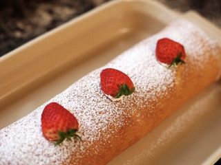 草莓奶油瑞士蛋糕卷,还可以像这样,在蛋糕卷表面均匀的撒上一层糖霜,然后把草莓切一半,将平整的一面扣上去,看起来像一个个完整的草莓,其实不是完整的草莓,因为完整的草莓放在上面不平稳会滚下来,也不是很美观。