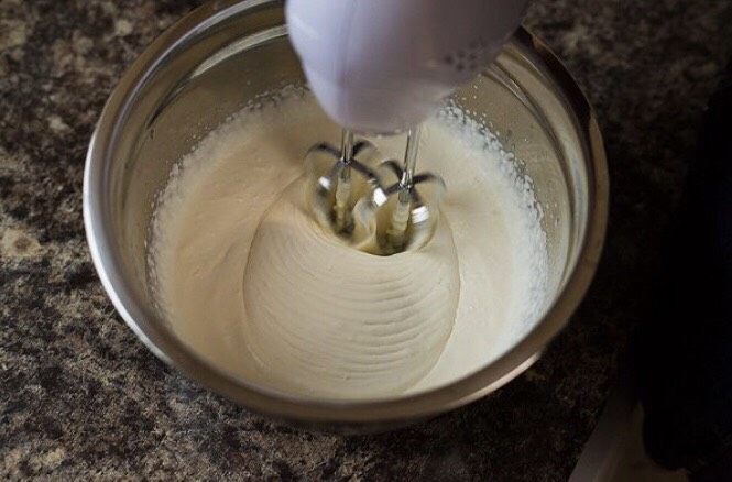 草莓奶油瑞士蛋糕卷,接下来我们要打发奶油,把20克糖粉一次性放入稀奶油中,用搅拌器低速搅拌,一直用低速就可以,要打很长时间,家里温度低就更容易打发,总之一直打到奶油出现纹路,并且纹路不消失就可以啦。
