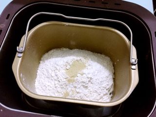 奶香排包,把主材料除了黄油外，都放入和面桶，顺序为牛奶、鸡蛋液、奶粉、糖和盐对角放，然后放面粉，酵母放最上面