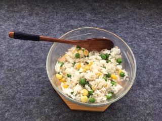 豌豆玉米饭团,用勺子把米饭团搅拌均匀。