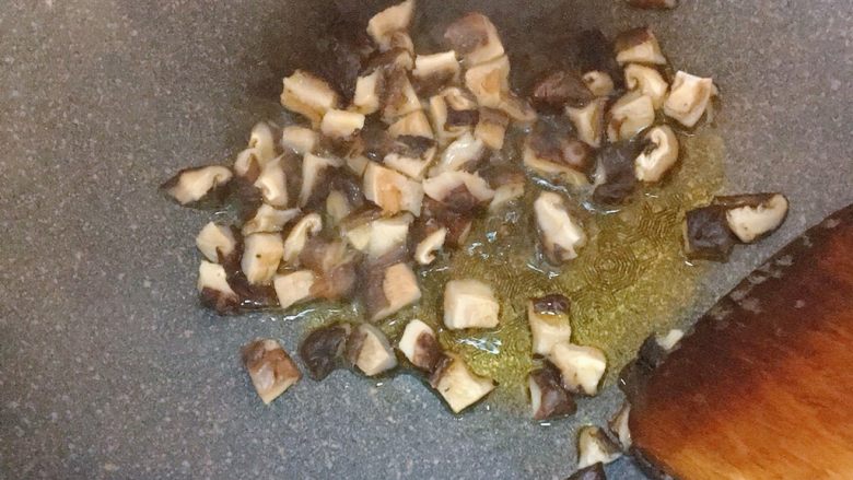 电饭煲排骨焖饭,锅中倒入少许油，爆香香菇，炒出香味