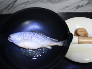 糖醋黄花鱼,油锅烧热，把沾了淀粉的鱼放进去煎。用不粘锅，只需放一点点油就可以了。
