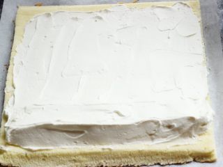 原味蛋糕卷,把奶油在蛋糕片上抹平，靠近身体的这头抹厚一些