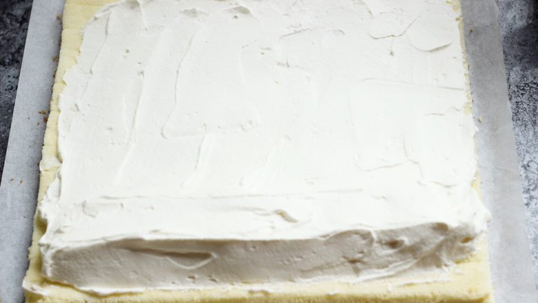 原味蛋糕卷,把奶油在蛋糕片上抹平，靠近身体的这头抹厚一些