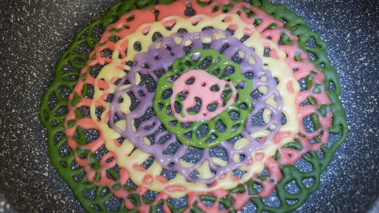 彩虹蕾丝蛋饼,好了，最终挤到中心处就完成啦。表面的面糊凝固就可以取出了，不要煎火大了，变成干脆面啊哈哈，开玩笑的，煎制单面就可以哦，不要翻面。