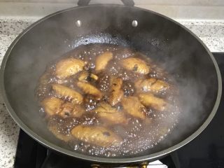 可乐鸡翅,大火烧开后，加入半勺老抽调色，盖上锅盖煮15分钟左右