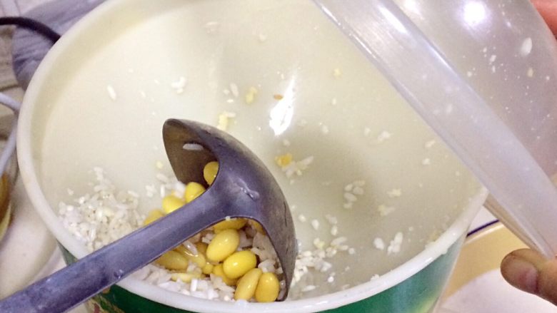 福建小吃—油饼,把混合好的黄豆、大米和水分次慢慢加入到磨浆机内研磨。