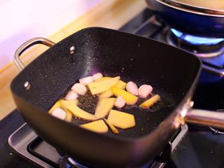 家庭版三杯鸡,热锅，下准备好的油爆香蒜头及姜片。