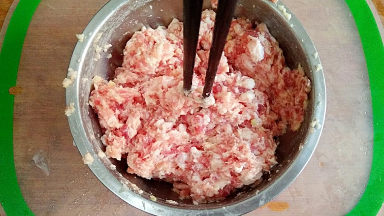 清汤狮子头,继续顺时针搅拌均匀，直到搅上劲儿，筷子能立在肉馅里不倒为宜。