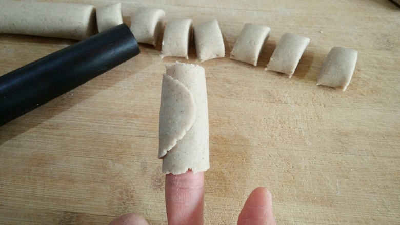莜面栲栳栳,用食指与拇指相配合，把面皮的一端揭起缠在食指上，将面皮在食指上绕一圈。