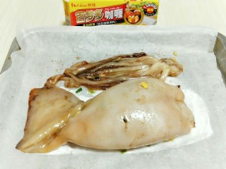 #鱿鱼与炒饭的新吃法#～咖喱鱿鱼包饭,将鱿鱼包饭放入垫有油纸的烤盘中。