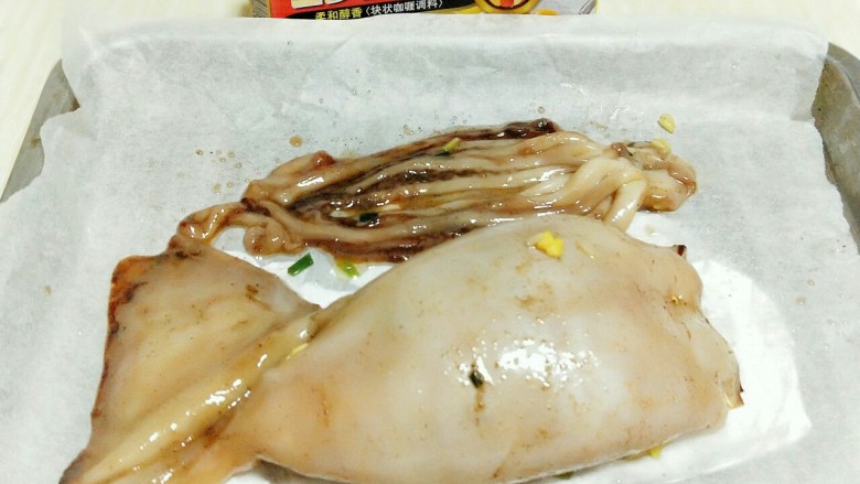 #鱿鱼与炒饭的新吃法#～咖喱鱿鱼包饭,将鱿鱼包饭放入垫有油纸的烤盘中。