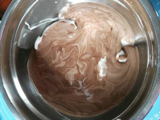 可可奶油蛋糕卷,将可可蛋黄糊全部倒入蛋白霜里快速的翻拌均匀。