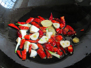 香菇土豆辣味鸡,炒锅烧热，放入姜、蒜、红辣椒煸香，可以捞出一半辣椒出来最后装饰用，不会太辣
