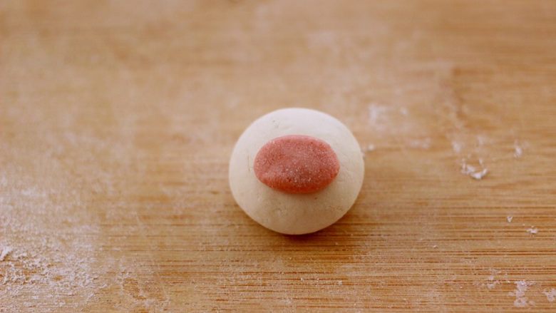 萌猪黑芝麻汤圆,把馅料包入以后、取一点粉色面团揉成长圆形、蘸点水粘在白色面团上做鼻子
