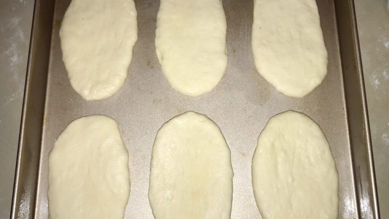 热狗面包,擀好的面，放在纸托上，或者直接放盘里。进行二次发酵。冬天最好是放烤箱发酵。发酵至两倍大。