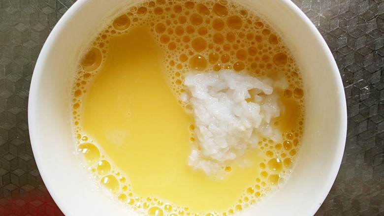 #宝宝辅食#米饭彩椒炖蛋,将米饭倒入蛋液中，搅拌均匀。