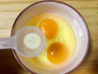 #快手营养早餐#黄金多彩花,取碗打入两个鸡蛋，放少许调味盐