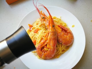 红虾意面,将意面盛入碗中，上面摆放好红虾和西兰花，现磨少许黑胡椒碎。