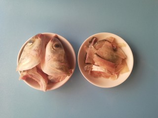 酸菜黑鱼汤,将黑鱼鱼头对半切开，并取出鱼肉切片，鱼骨和鱼片分装