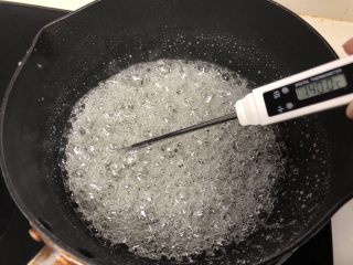 熬糖版花生牛轧糖,糖浆熬至138度以上，一般我煮到142度，这个过程很关键，一定要有耐心，熬糖温度一定要到位，温度计测量温度的时候温度计尽量不要接触锅底和锅边，会出现温度虚高现象，糖浆熬到142度就可以关火了。
如果没有温度计的也可以学着看状态，糖浆刚沸腾后锅里一直冒大泡泡，熬到一定温度的时候会变成许多密集的小泡泡，这个时候糖浆的温度就差不多了，熬糖浆的时间跟你的火力大小、锅的厚度、受热度都有关系，另外还有一个简单测试温度的办法，准备一碗冷水，糖浆状态差不多到了以后，用一根筷子蘸点糖浆迅速滴到冷水里，如果糖浆变硬，变脆，可以轻松折断就表示糖浆的温度可以了。
新手做熬糖版建议备个温度计。