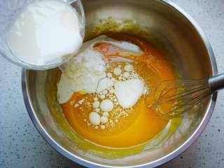红枣葡萄干蛋糕杯,搅拌均匀后，加入牛奶和玉米油。