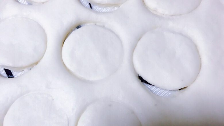 肥美小蜜蜂椰蓉包,白色面团擀成薄饼，取一个矿泉水的瓶盖，在面团上盖出12个圆形