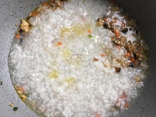 香菇瘦肉粥,将煮好的稀饭倒入搅拌均匀盖锅煮三分钟
