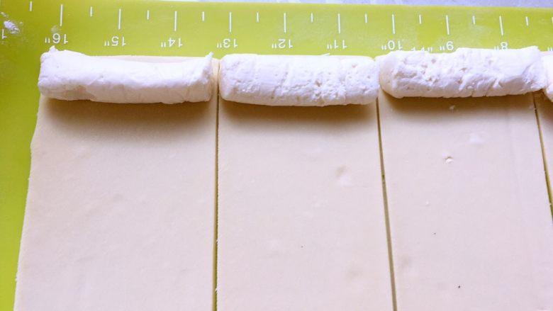 白富美跟粉小妹,冰箱取出冷冻的奶酪条，切成面片同等宽度，摆放在面片的一侧