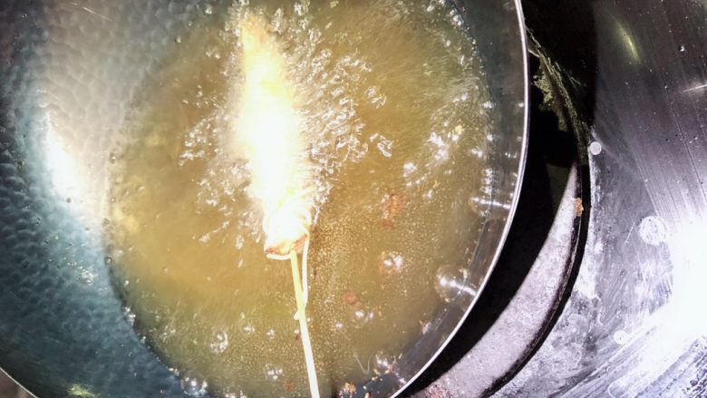 签签虾,锅中放油加热到7成热，中小火炸缠好的基围虾。（最好用平底锅多放点油）