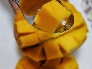 百变水果—芒果法式软糖,芒果对半切开。挖出果肉
