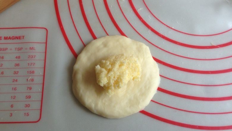 椰香小面包,将小面团擀圆，放上9-10克的馅料，收口