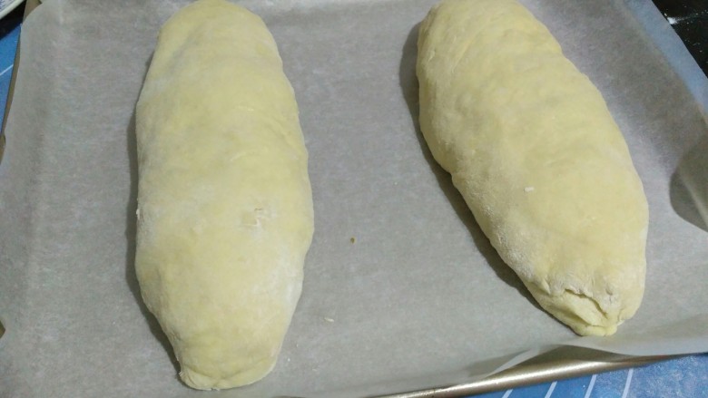 红薯软欧,两端捏紧，放入烤盘，放在温暖的地方进行二次发酵，发酵至两倍大