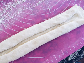 酸奶老面包-可以拉丝的面包,取其中的一块，进行整形的工作。将面团擀成长条形，然后两端向中间对折。