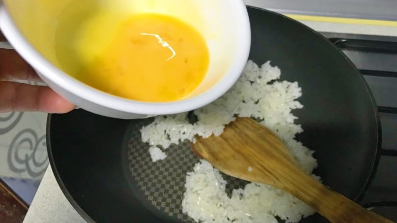 彩虹蛋炒饭,倒入蛋黄，迅速翻炒，让每一粒米粒上都沾满点黄。