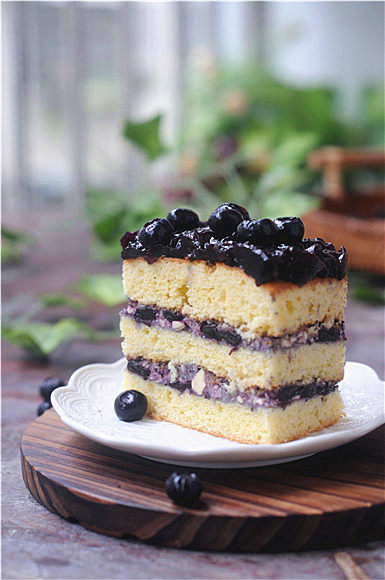 蓝莓蛋糕,把变得浓稠的蓝莓顶料涂抹在蛋糕顶部，再放上新鲜的蓝莓，放入冰箱冷藏4个小时，使蓝莓顶料完全凝固后就可以食用了。