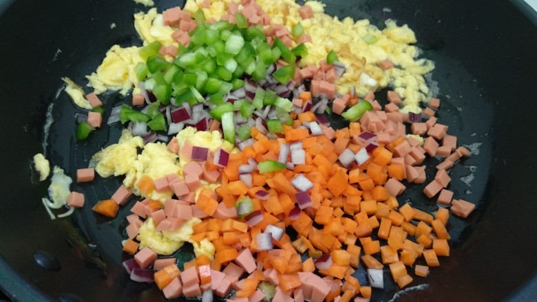 百变水果+小金鱼咖喱炒饭,倒入胡萝卜，洋葱、火腿肠和青菜椒翻炒至快熟。
