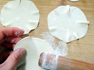 烧麦――剩米饭也有春天,然后再用擀面杖一头两厘米左右的位置把饺子皮边上擀一遍，一边擀一边转皮，把饺子皮擀出薄薄的荷叶边。