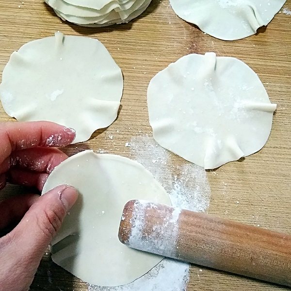 烧麦――剩米饭也有春天,然后再用擀面杖一头两厘米左右的位置把饺子皮边上擀一遍，一边擀一边转皮，把饺子皮擀出薄薄的荷叶边。