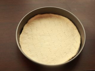 萨拉米培根玉米披萨,用叉子在表面叉孔