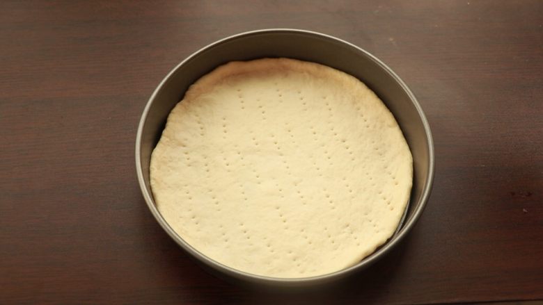 萨拉米培根玉米披萨,用叉子在表面叉孔