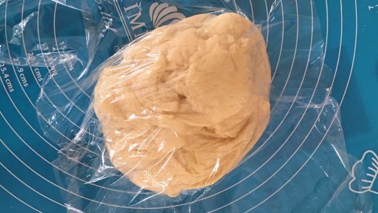超松软奶香小面包,取出面团，挤压排气保鲜膜覆盖醒15分钟