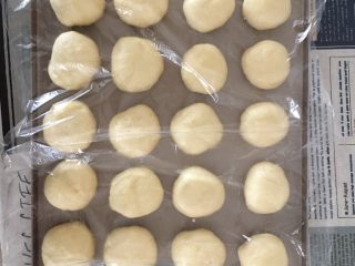 超松软奶香小面包,然后把20个面团依次留出距离放入烤盘，保鲜膜覆盖，烤箱选发酵功能进行二次发酵