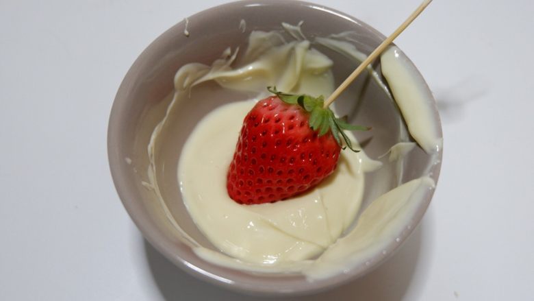 百变水果—情人节巧克力草莓,取一颗草莓，在巧克力液中滚粘均匀