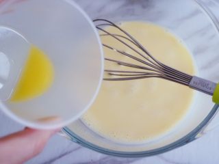 奶香浓郁的苹果千层派,我们将化开的黄油倒入搅拌均匀的蛋糊中，搅拌到无油星