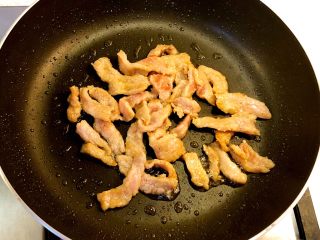 手撕杏鲍菇炒肉片,热锅下油，爆炒猪肉片至变色后取出待用。