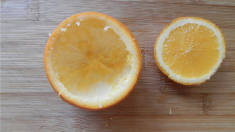 国橙蒸枸杞蛋,用一个不锈钢勺子，把橙子里面的果肉给挖出来，留下完整的球形橙子皮容器及其小盖子。