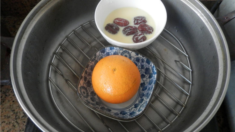 国橙蒸枸杞蛋,蒸锅水开后，将橙子放入，加盖中火蒸约十分钟（锅边要留一条小缝，防止水蒸气回流影响成品）。