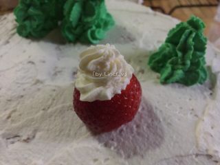 圣诞场景草莓裸蛋糕,在大的一部分挤上白奶油
